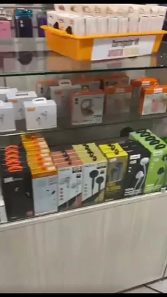 Prateleira de vidro com caixas de fones de ouvido