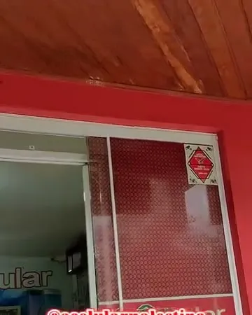 Fachada vermelha com as portas de vidro da loja