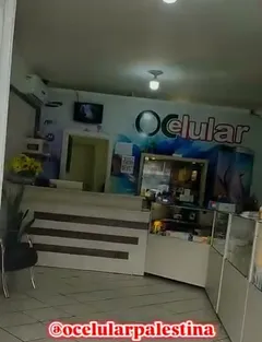 Interior da loja, com o balcão e o nome ÔCelular na parede