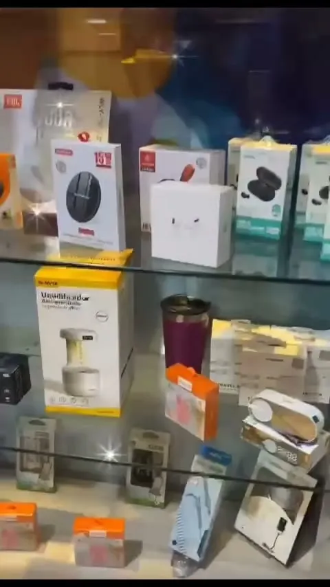 Vitrine de vidro da loja, iluminada, com fones e acessórios